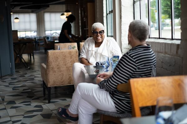 Oreatha’s at the Point co-owners Deborah VanTrece, left, and Shea Embry chat before the restaurant opens for brunch Saturday, June 25, 2022. (Ben Gray for the AJC)