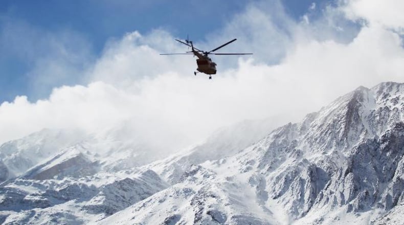 In this photo provided by Tasnim News Agency, a rescue helicopter flies over the Dena mountains while searching for wreckage of a plane that crashed on Sunday, in southern Iran, Monday, Feb. 19, 2018. (Ali Khodaei/Tasnim News Agency via AP)