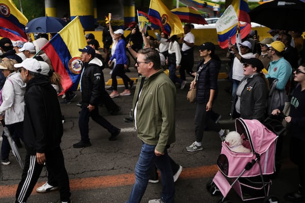 People march to the clinic where Colombian Senator Miguel Uribe Turbay is being treated after he was shot, in Bogota, Colombia, Sunday, June 8, 2025. (AP Photo/Ivan Valencia)