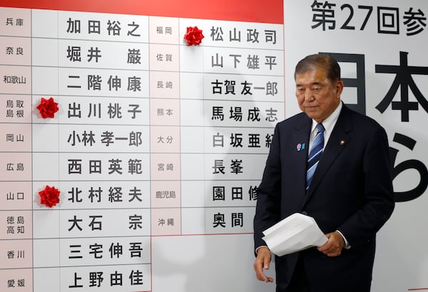 Shigeru Ishiba, Japan's Prime Minister and president of the ruling Liberal Democratic Party (LDP), walks before a board with few red paper roses showing elected candidate at the LDP headquarters in Tokyo, Sunday, July 20, 2025. (Franck Robichon, Pool Photo via AP)