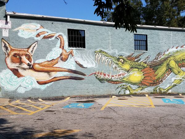 On Flat Shoals Avenue, a work by Shaun Thurston comes into view. Thurston’s work is colorful, fantastical and usually involves animals. This mural of a fox and a dragon is no exception.
