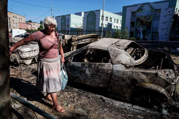 A local woman walks past cars destroyed by a Russian strike in Kyiv, Ukraine, on Friday, July 4, 2025. (AP Photo/Evgeniy Maloletka)