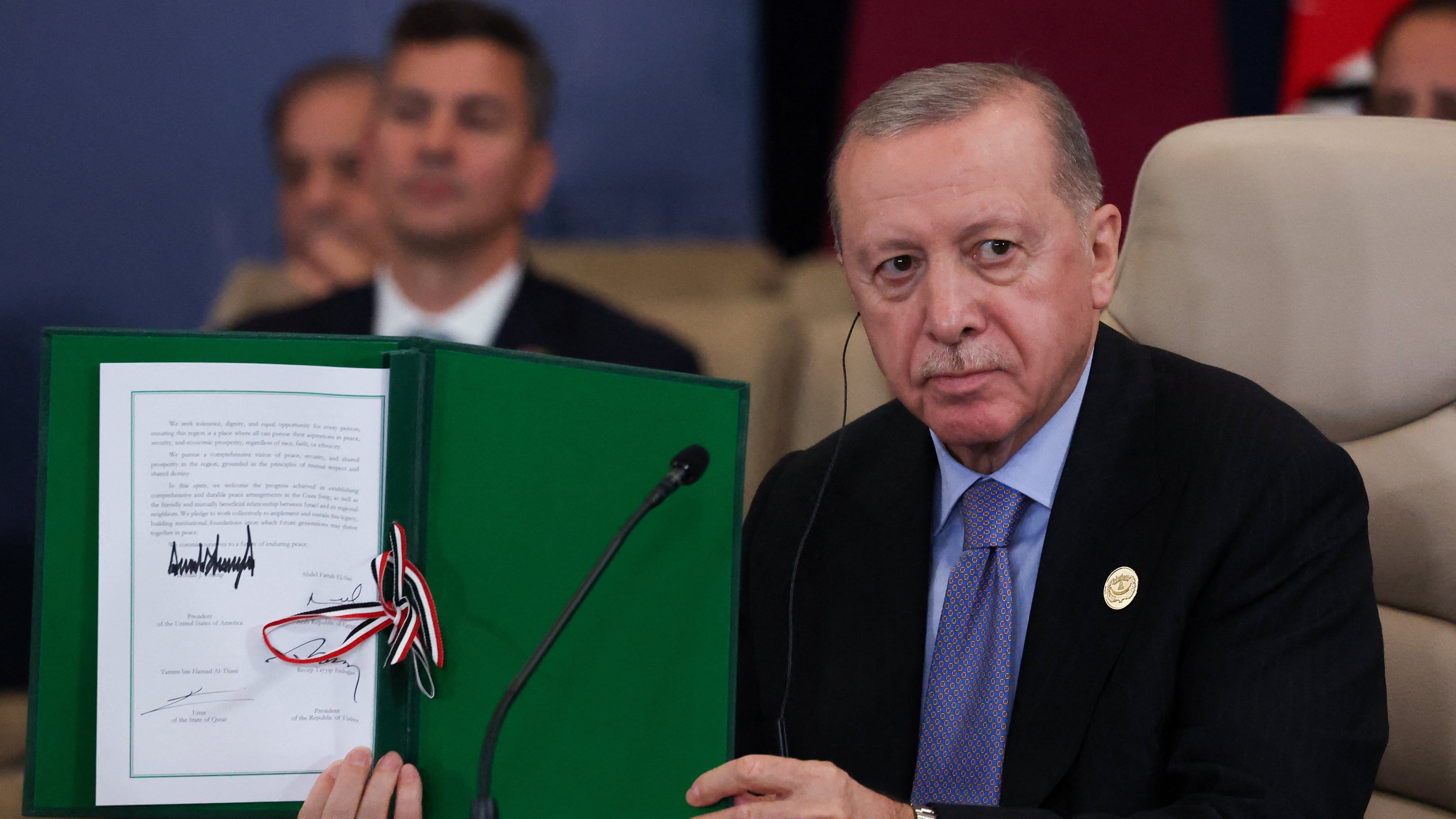 Turkey's President Recep Tayyip Erdogan holds a signed document during a summit to support ending the more than two-year Israel-Hamas war in Gaza after a breakthrough ceasefire deal, Monday, Oct. 13, 2025, in Sharm El Sheikh, Egypt. (Suzanne Plunkett/Pool via AP)