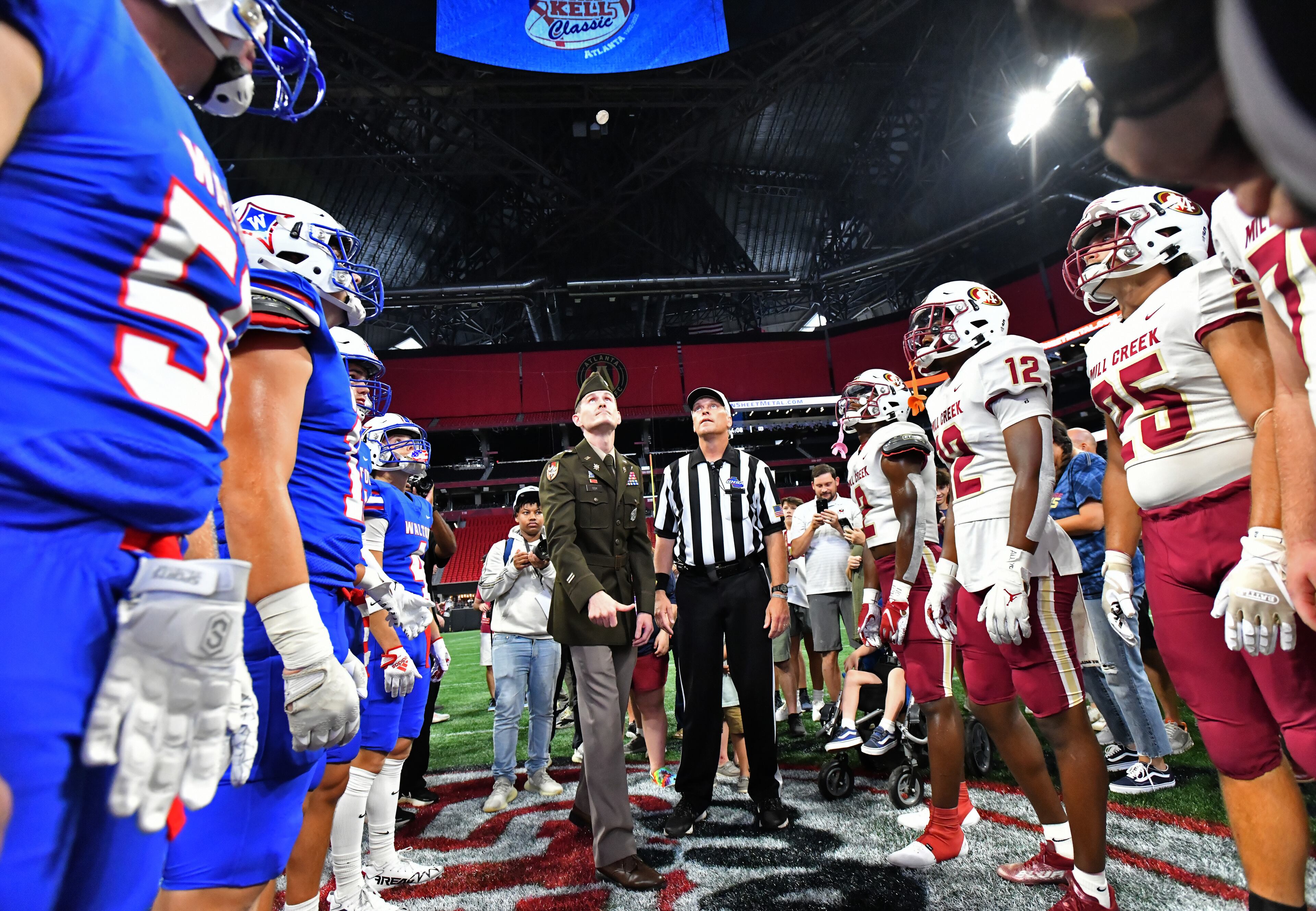 Walton (left) and Mill Creek players gather for the coin toss before their game during the 2022 Corky Kell Classic at Mercedes Benz Stadium, 2022. The Corky Kell Classic (now called the Corky Kell + Dave Hunter Classic) has kicked off the Georgia high school football season every year since 1992. (Hyosub Shin/AJC)