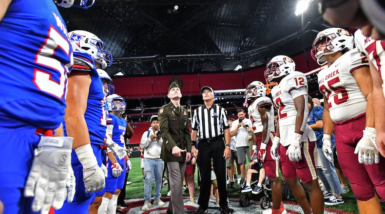 August 20 , 2022 Atlanta - Walton (left) and Mill Creek players gather for the coin toss before their game during the 2022 Corky Kell Classic at Mercedes Benz Stadium on Saturday, August 20, 2022. The Corky Kell Classic has kicked off the Georgia high school football season every year since 1992, and is gearing up to stage a captivating four-day, 11-game lineup to celebrate its 31st anniversary this year. (Hyosub Shin / Hyosub.Shin@ajc.com)