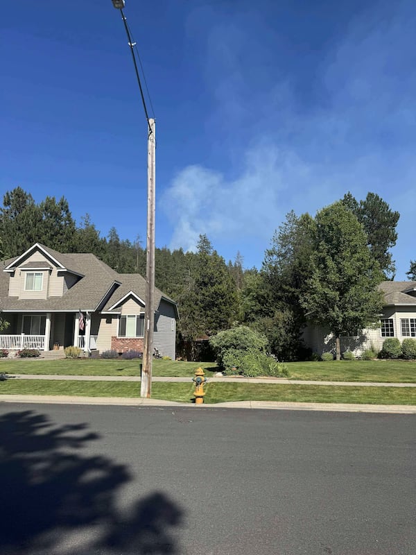 In this photo provided by Mark Lathrop, a blaze burns in a community near Canfield Mountain where a sniper ambushed firefighters responding to the fire, just north of Coeur d’Alene, Idaho, Sunday, June 29, 2025. (Mark Lathrop via AP)
