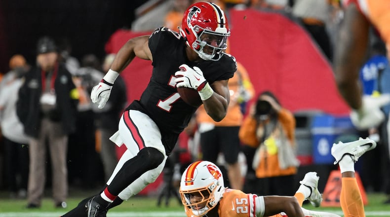 Atlanta Falcons running back Bijan Robinson carries the ball past Tampa Bay Buccaneers cornerback Jacob Parrish during the first half of Thursday's game. (Jason Behnken/AP)