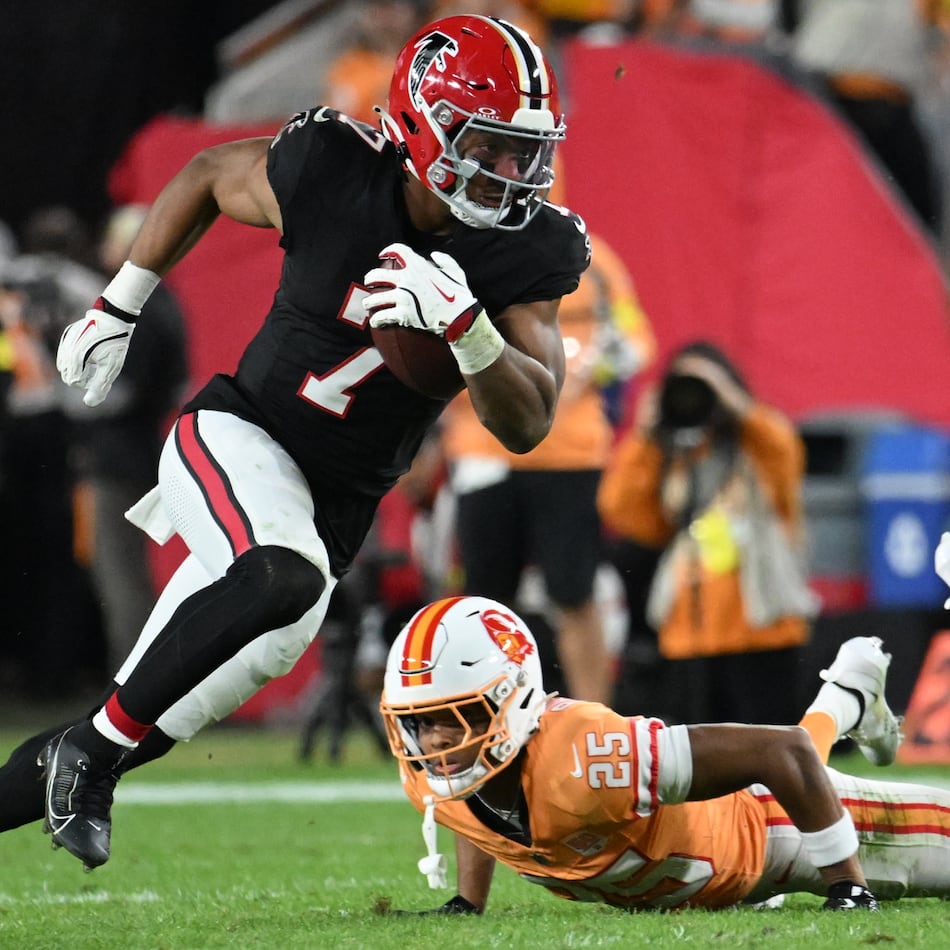 Atlanta Falcons running back Bijan Robinson carries the ball past Tampa Bay Buccaneers cornerback Jacob Parrish during the first half of Thursday's game. (Jason Behnken/AP)