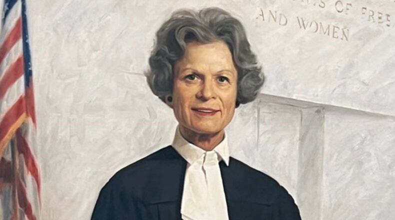 Georgia Court of Appeals Judge Dorothy Toth Beasley, the court's first female judge and female chief judge, stands in front of the court's motto – to which she added the words "and women" – in her official portrait. Beasley, who died May 19, was Georgia's first female appellate judge.