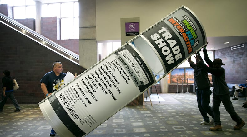 USE THIS PHOTO WITH 5 THings ASF
From left, Armando Valdes, Ron Dorsey and David Monroe with Freeman Decorating push up a sign in the hallway for SXSW 2016 at the Convention Center on Thursday, March 10, 2016. DEBORAH CANNON / AMERICAN-STATESMAN
