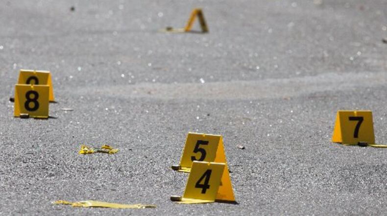Evidence tags and bullet casings lay on a crime scene near where a body was found in 2015, in DeKalb County, Ga. SPECIAL / BRANDEN CAMP