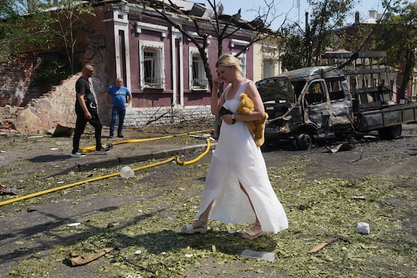 A woman reacts as she leaves her home that was destroyed by a Russian airstrike in Kharkiv, Ukraine, Monday, July 7, 2025. (AP Photo/Andrii Marienko)