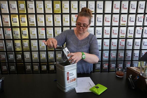 Owner Lisa McDonald packages loose leaf tea orders at the TeaHaus Thursday, April 24, 2025, in Ann Arbor, Mich. (AP Photo/Paul Sancya)