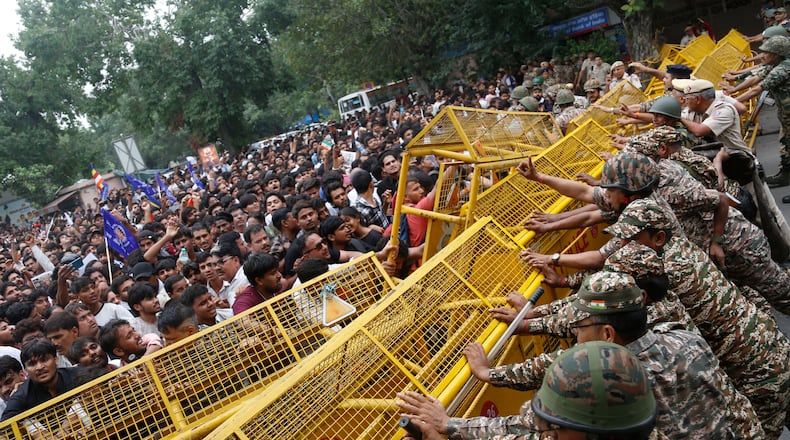 Supporters of the Cockroach Janta Party push against a barricade as they attempt to march to India's Parliament, demanding the resignation of the education minister, in New Delhi, Monday, July 20, 2026. (AP Photo/Shekhar Yadav)