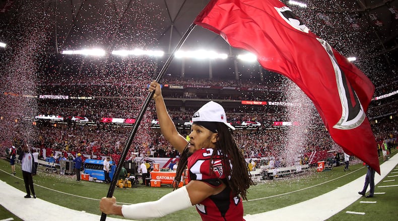 Jalen Collins runs through the field with a Falcons flag after defeating the Green Bay Packers in the NFC Championship Game at the Georgia Dome on January 22, 2017 in Atlanta, Georgia. The Falcons defeated the Packers 44-21. (Tom Pennington/Getty Images)