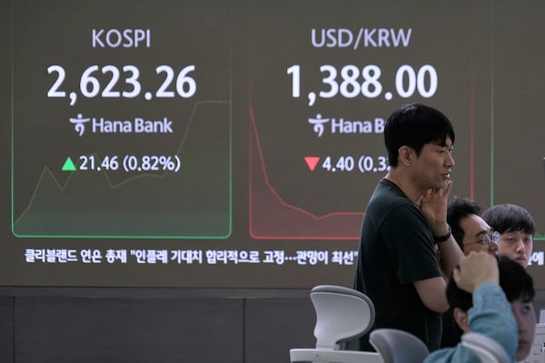 Currency traders watch monitors near a screen showing the Korea Composite Stock Price Index (KOSPI), left, and the foreign exchange rate between U.S. dollar and South Korean won at the foreign exchange dealing room of the KEB Hana Bank headquarters in Seoul, South Korea, Wednesday, May 21, 2025. (AP Photo/Ahn Young-joon)