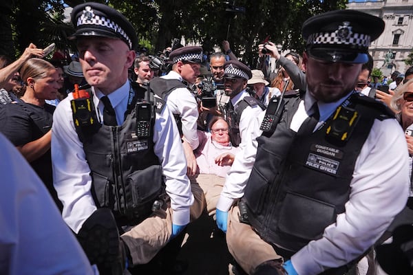 Police officers remove a person after they took part in a protest in Parliament Square, to call for de-proscription of 'Palestine Action' after a ban against the organisation was announced, in London, Saturday July 12, 2025. (James Manning/PA via AP)