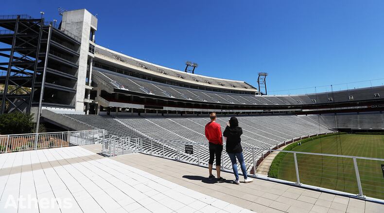 Local residents Dan Haybery and Alexis Biaggi pause to take in an empty Sanford Stadium during a walk across the University of Georgia campus from their home in downtown Athens on Thursday, April 2, 2020. Curtis Compton ccompton@ajc.com