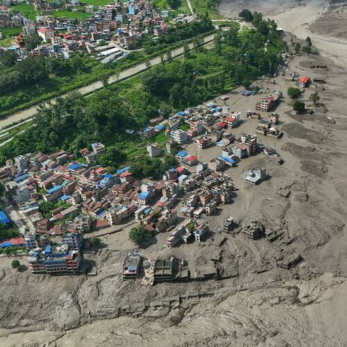 Damaged houses stand precariously near the swollen, debris-choked banks of the Trishuli River after flash floods in Nepal's Nuwakot district on Wednesday, Aug. 26, 2026. (AP Photo/Niranjan Shrestha)