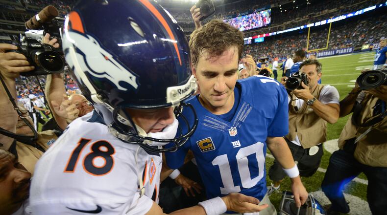 EAST RUTHERFORD, NJ - SEPTEMBER 15: Quarterback Peyton Manning #18 of the Denver Broncos and brother quarterback Eli Manning #10 of the New York Giants shake hands at the end of the Denver Broncos 41-23 win over the New York Giants at MetLife Stadium on September 15, 2013 in East Rutherford, New Jersey. (Photo by Ron Antonelli/Getty Images)