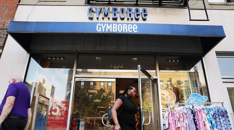 People walk by the children's clothing retailer Gymboree, which will reportedly file for bankruptcy protection.