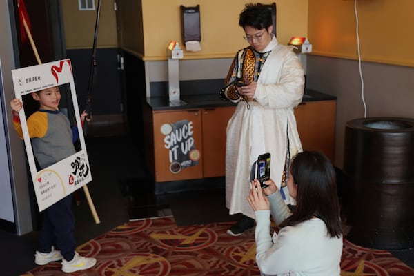 This photo provided by Jialin Sun shows Zhao Yuanyuan taking a picture of her 7-year-old son Jiang Wei’en, at a movie screening of Ne Zha 2 at a IMAX screen in Columbia Md. on March 1. (Jialin Sun via AP)