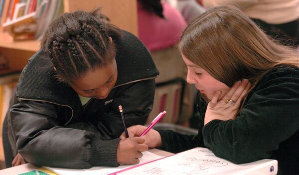 061204 - NEWNAN, GA -- Ruth Hill Elementary School has been drastically changed in it's racial makeup due to the attempted end of a thirty-six year old federal desegregation order. The school has gone from 74% black to 41% in a years time. Many white parents have learned to embrace the new Coweta County school guidelines. Ten year olds (left to right) (cq) Alexus Alford and Cierra Gosnell conspire on a piece of parwork during recess period in Ms. Angela Brown's classroom. (W.A. BRIDGES JR. / AJC staff)