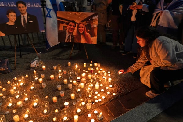 People gather to light candles in a makeshift memorial to honor Yaron Lischinsky and Sarah Milgrim who were killed as they left an event at the Capital Jewish Museum in Washington, during a candlelight vigil outside of the White House in Washington, Thursday, May 22, 2025. (AP Photo/Jose Luis Magana)