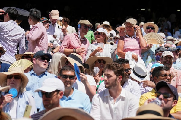The crowd swelter as Taylor Fritz of the U.S. plays Spain's Carlos Alcaraz in a men's singles semifinal at the Wimbledon Tennis Championships in London, Friday, July 11, 2025. (AP Photo/Kin Cheung)