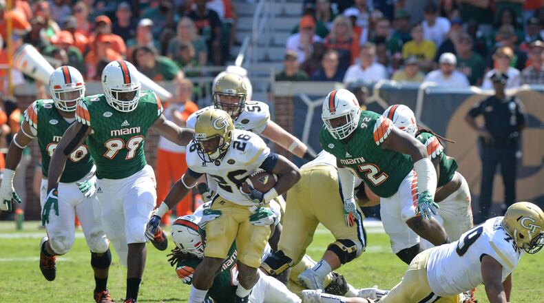 Georgia Tech Yellow Jackets running back Dedrick Mills (26) eludes a tackle by Miami Hurricanes defensive back Jamal Carter Sr. (6) in the second half at Bobby Dodd Stadium on Saturday, October 1, 2016. Miami Hurricanes won 35-21 over the Georgia Tech Yellow Jackets. HYOSUB SHIN / HSHIN@AJC.COM