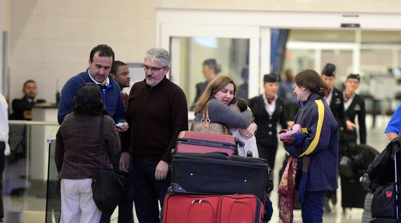 JANUARY 28, 2017 ATLANTA Mansour Kenereh (center in purple sweater) reunites with family members in the International arrivals lobby at Hartsfield Jackson International Airport Saturday January 25, 2017.The family of 3 were among several people detained at the Customs and Border Protection office following an executive order from President Trump limiting immigration. Kent D. Johnson/AJC *** FAMILY MEMBERS DECLINED TO BE IDENTIFIED***