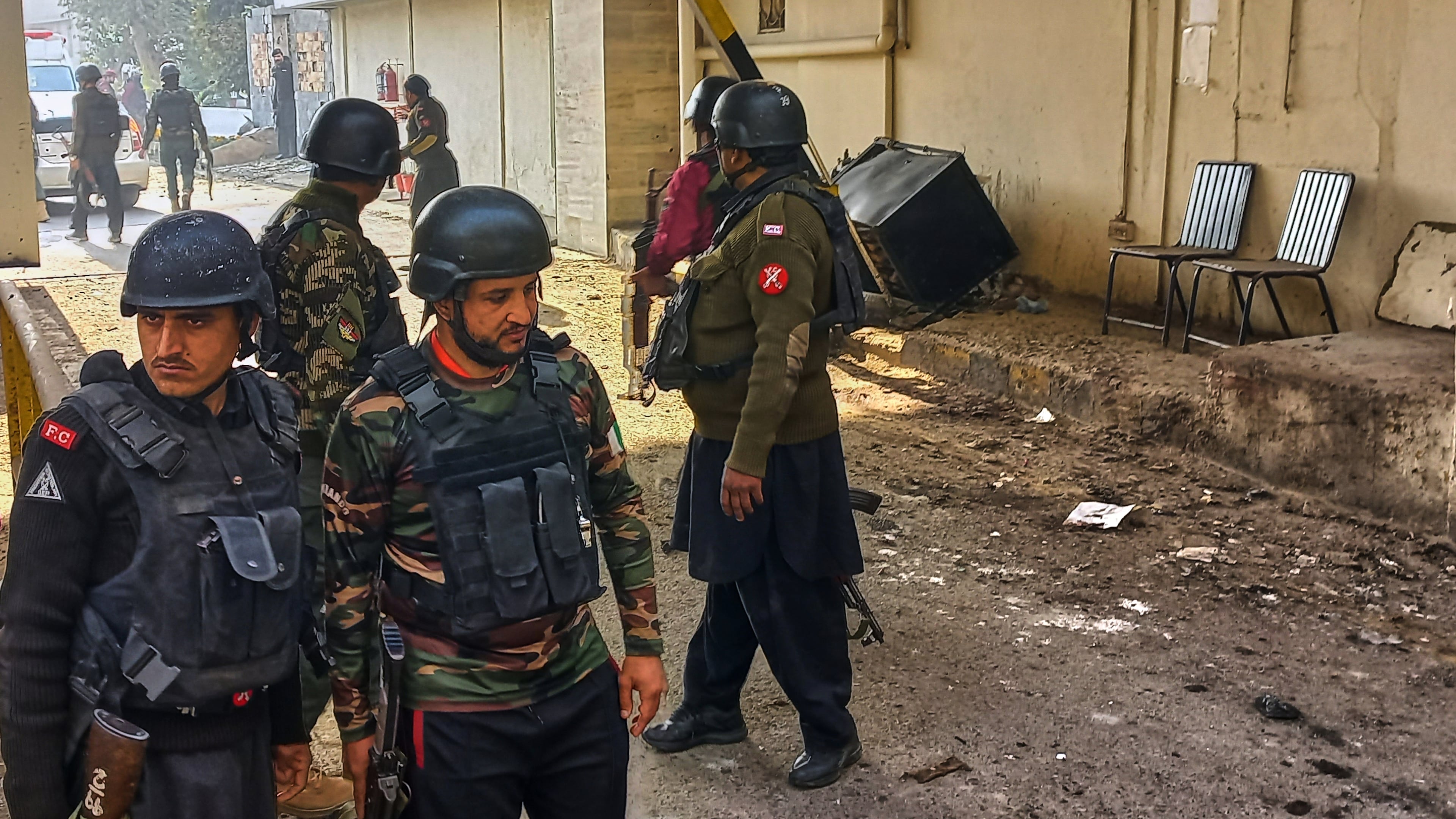 Security officials gather at the site of a suicide bombing at the main gate of headquarters of the Federal Constabulary (FC), in Peshawar, Pakistan, Monday, Nov. 24, 2025. (AP Photo/Muhammad Zubair)
