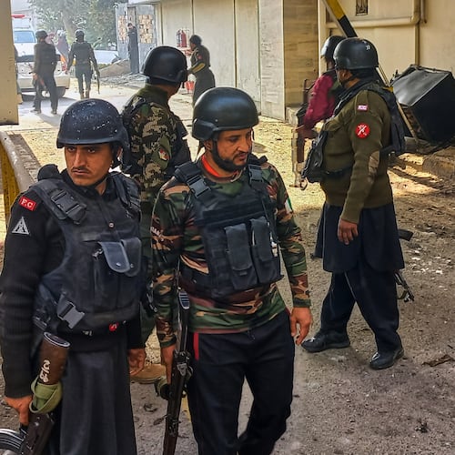 Security officials gather at the site of a suicide bombing at the main gate of headquarters of the Federal Constabulary (FC), in Peshawar, Pakistan, Monday, Nov. 24, 2025. (AP Photo/Muhammad Zubair)