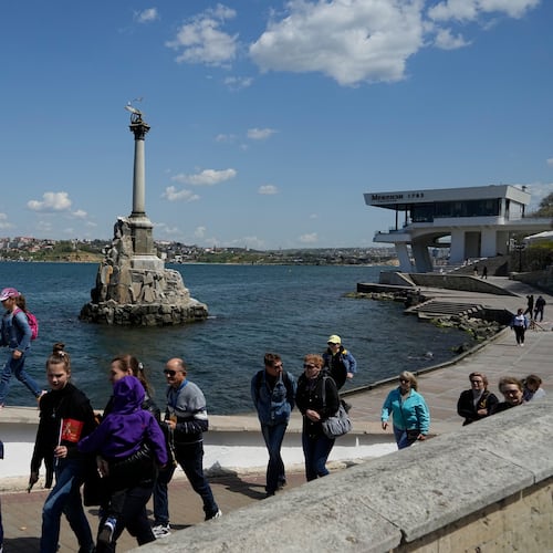 FILE - Tourists walk along an embankment in Sevastopol, Crimea, Monday, May 2, 2022. (AP Photo, File)