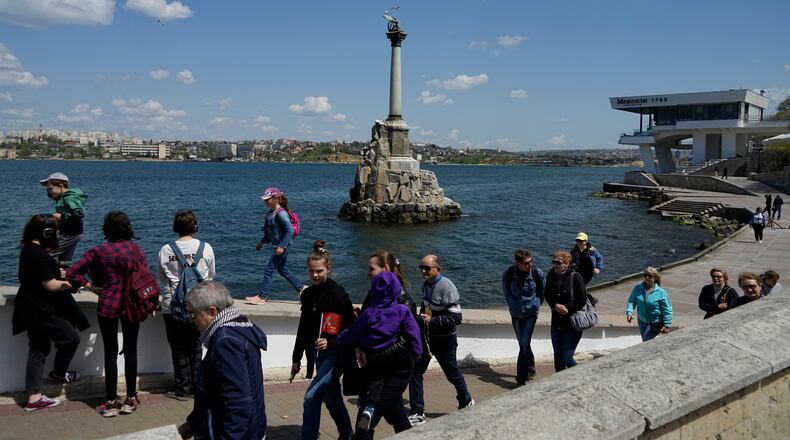 FILE - Tourists walk along an embankment in Sevastopol, Crimea, Monday, May 2, 2022. (AP Photo, File)