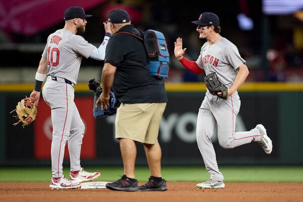 Boston Red Sox's Roman Anthony, right, runs to greet Trevor Story (10) at the end of a baseball game against the Seattle Mariners Monday, June 16, 2025, in Seattle. (AP Photo/John Froschauer)