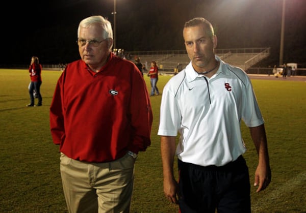 Former Sandy Creek coach Rodney Walker (left) walks off the field with his son, Sandy Creek coach Chip Walker, after their win over Eastside on Friday, Oct. 1, 2010, in Tyrone. The Walkers became the first father-son coaches to win state championships. (Jason Getz/AJC)