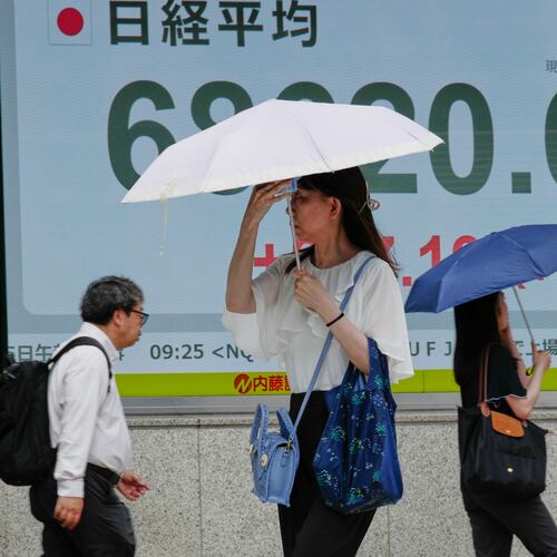 People walk in front of an electronic stock board showing Japan's Nikkei 225 index at a securities firm Wednesday, July 15, 2026, in Tokyo. (AP Photo/Eugene Hoshiko)