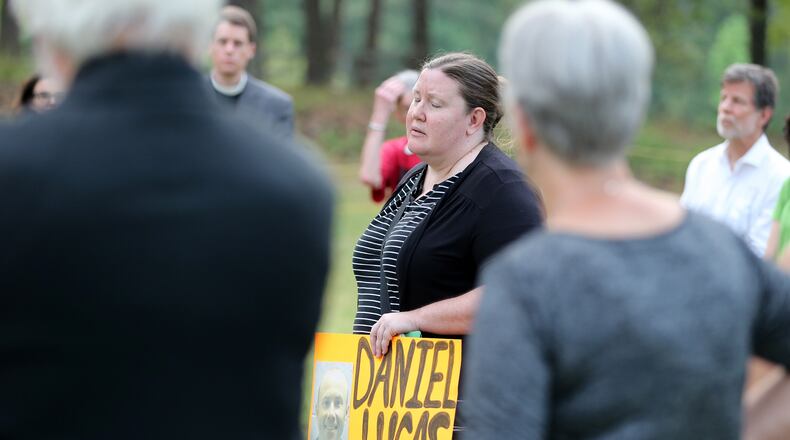 Mary Catherine Johnson, with Georgians for Alternatives to the Death Penalty, holds a photo of Daniel Anthony Lucas while leading a vigil outside of the Georgia Diagnostic and Classification State Prison in Jackson on Wednesday evening April 27, 2016 at the time Lucas was scheduled to be executed for the 1998 murders of a Jones County father and his two children. Ben Gray / bgray@ajc.com
