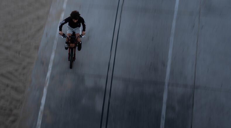 A boy rides an e-bike in Santa Monica, Calif., Monday, Aug. 10, 2026. (AP Photo/Jae C. Hong)