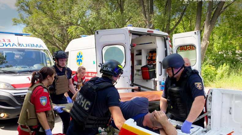 In this photo provided by the Ukrainian Emergency Services on Monday, June 29, 2026, a rescue worker with paramedics move an injured man into an ambulance after a Russian drone strike on passengers minivan in Dnipropetrovsk region, Ukraine. (Ukrainian Emergency Service via AP)