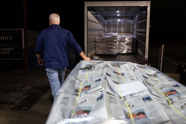 Jeff Hood, owner of Trans-United Expedited, hauls stacks of The Atlanta Journal-Constitution newspaper to a waiting truck outside the printing press. (Arvin Temkar/AJC)