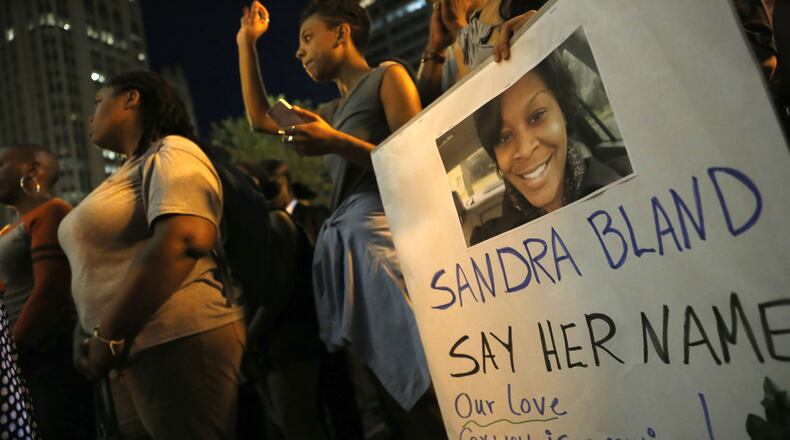 A demonstrator holds a Sandra Bland sign during a candlelight vigil July 28, 2015, near the DuSable Bridge on Michigan Avenue in Chicago. Bland, 28, died of apparent suicide in her jail cell three days after a July 10, 2015, traffic stop near the campus of Prairie View A&M University in Prairie View, Texas, where she attended college and had just gotten a new job.