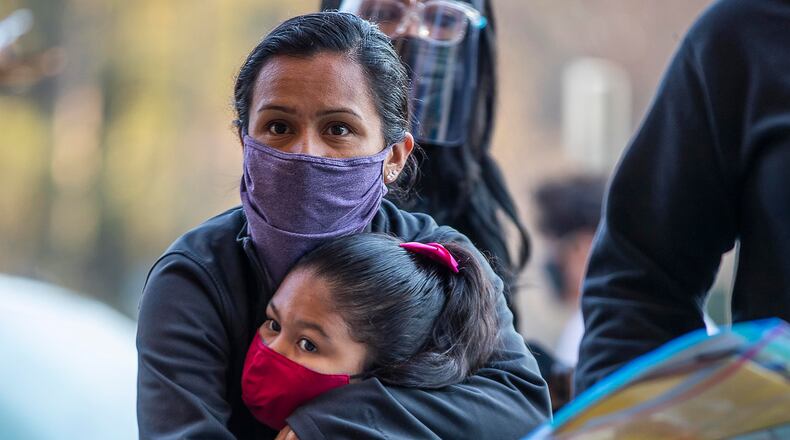 Jazmin Martinez gives a big hug to her kindergartner daughter, Jazmin Lorenzo, while dropping her off during the first day of in-person learning for DeKalb County Public Schools at John R. Lewis Elementary School in Atlanta, Tuesday, March 9, 2021. (Alyssa Pointer / Alyssa.Pointer@ajc.com)