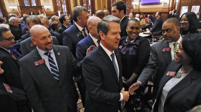 Gov. Brian Kemp shakes hands with lawmakers as he departs the House after he delivered his first State of the State address. BOB ANDRES /BANDRES@AJC.COM