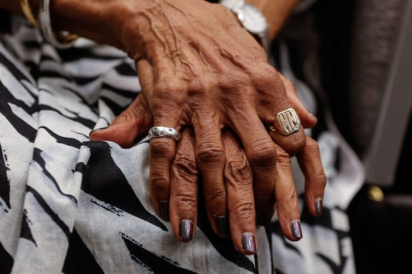 Judith Thornton folds her hands while listening to family members speak at a luncheon during the Thornton Family Reunion. (Natrice Miller/AJC)