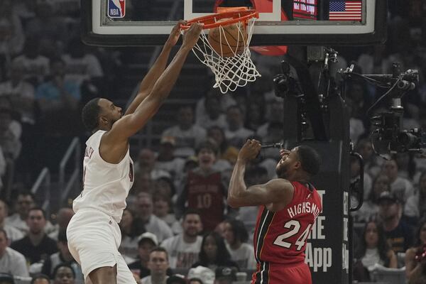 Cleveland Cavaliers forward Evan Mobley (4) left, dunks over Miami Heat forward Haywood Highsmith (24) in the first half in Game 1 of an NBA first-round playoff series, Sunday, April 20, 2025, in Cleveland. (AP Photo/Sue Ogrocki)