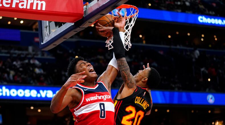 Atlanta Hawks forward John Collins (20) blocks a shot by Washington Wizards forward Rui Hachimura (8) during the first half of an NBA basketball game, Friday, March 4, 2022, in Washington. (AP Photo/Evan Vucci)