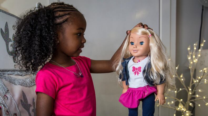A little girl plays with a 'My Friend Cayla' doll at a store in London, England. The doll, which uses Bluetooth technology to connect to Android and iOS devices, is on a warning list for potential toy hacking threats.