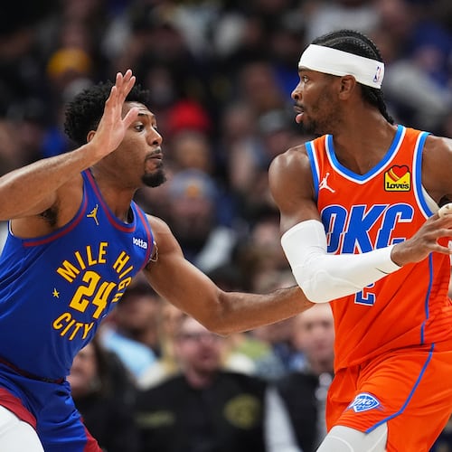 Oklahoma City Thunder guard Shai Gilgeous-Alexander, right, looks to pass the ball as Denver Nuggets guard Jalen Pickett defends in the first half of an NBA basketball game Sunday, Feb. 1, 2026, in Denver. (AP Photo/David Zalubowski)